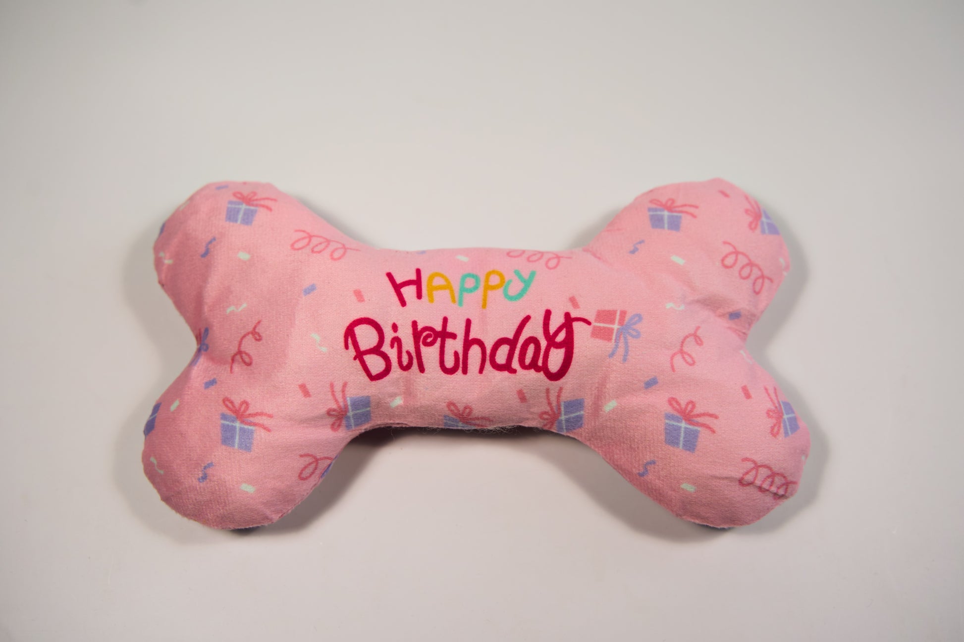 Happy birthday pink plush bone to celebrate your dog's birthday.|Os en peluche rose happy birthday pour fêter l'anniversaire de votre chien.