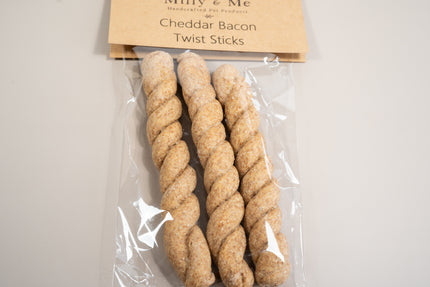 Vue rapprochée des 3 friandises pour chiens au bacon et au cheddar sous forme de bâtonnets torsadés.