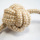 Vue rapprochée de la balle de poing de singe pour chiens en corde de coton et sisal avec noeuds aux extrémités.