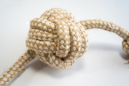 Close-up view of the monkey fist ball for dogs made from cotton rope and sisal with knots at the ends.