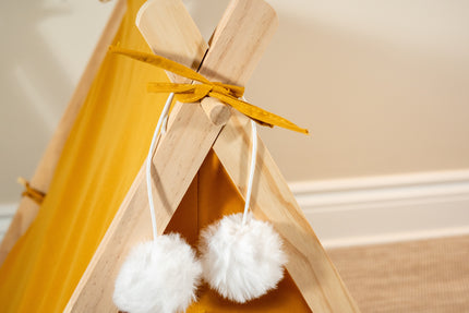 Vue rapprochée des pompons décoratifs blancs super doux de la tente orange pour animaux.