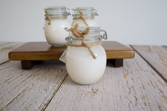 Three small glass jar bottles filled with pet shampoo.|Trois petits flacons en verre remplis de shampoing pour animaux.