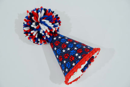 Chapeau de fête pour animal, avec un motif rouge, blanc et bleu sur fond gris clair.