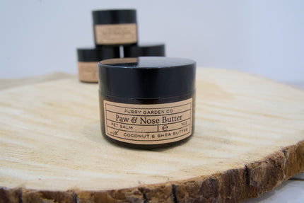 Pot de baume pour animaux Beurre pour pattes & museau sur une surface en bois.