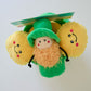 Top view of the dog plush toy resembling a leprechaun with gold coins on a white background.