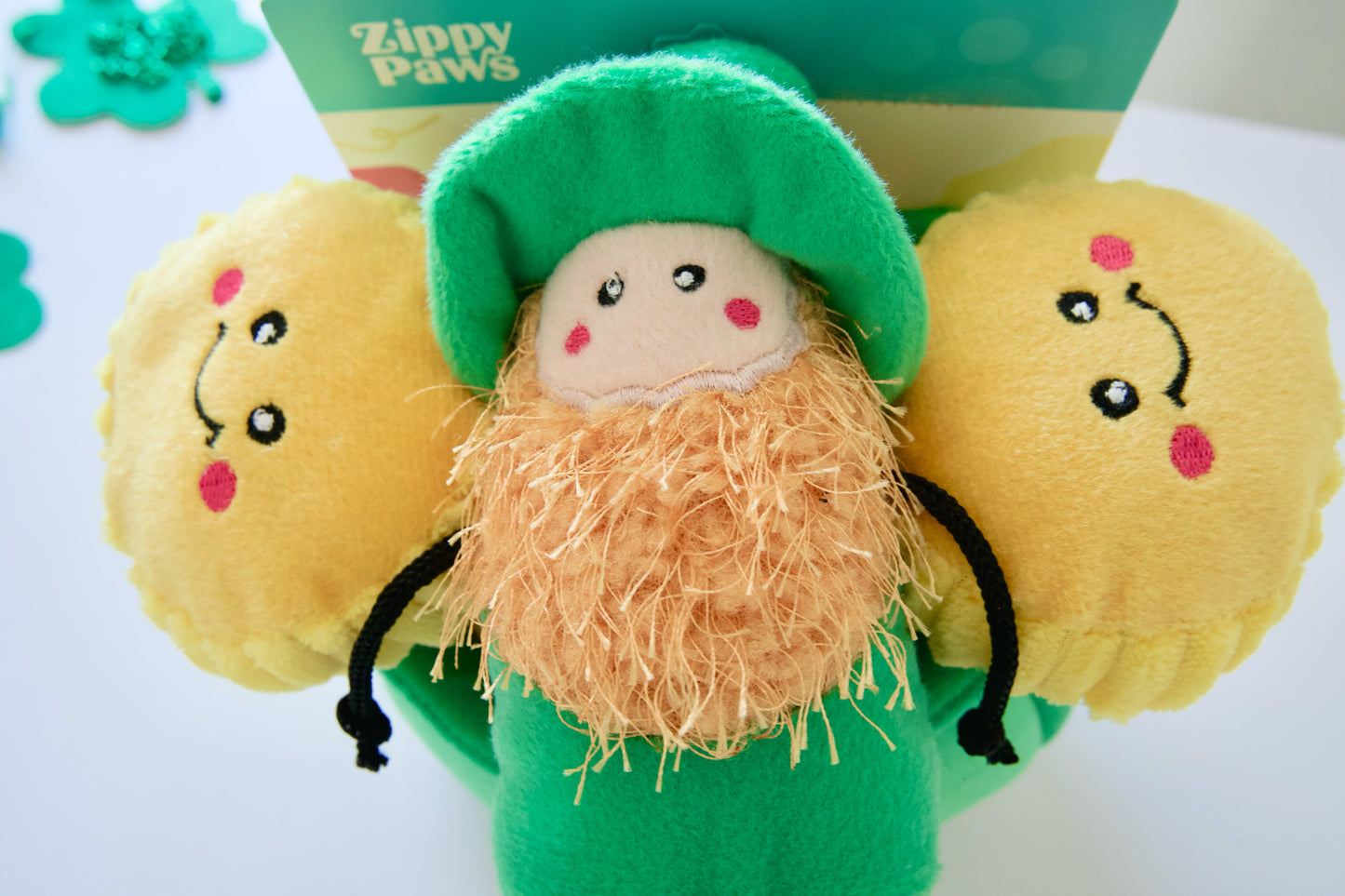 Dog toy figure of a leprechaun with gold coins and a green hat.