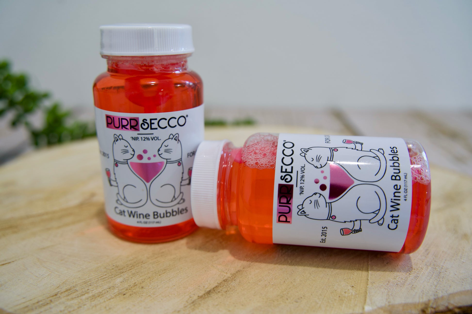 Deux bouteilles de « Cat Wine Bubbles » de Purrsecco sur une surface en bois.