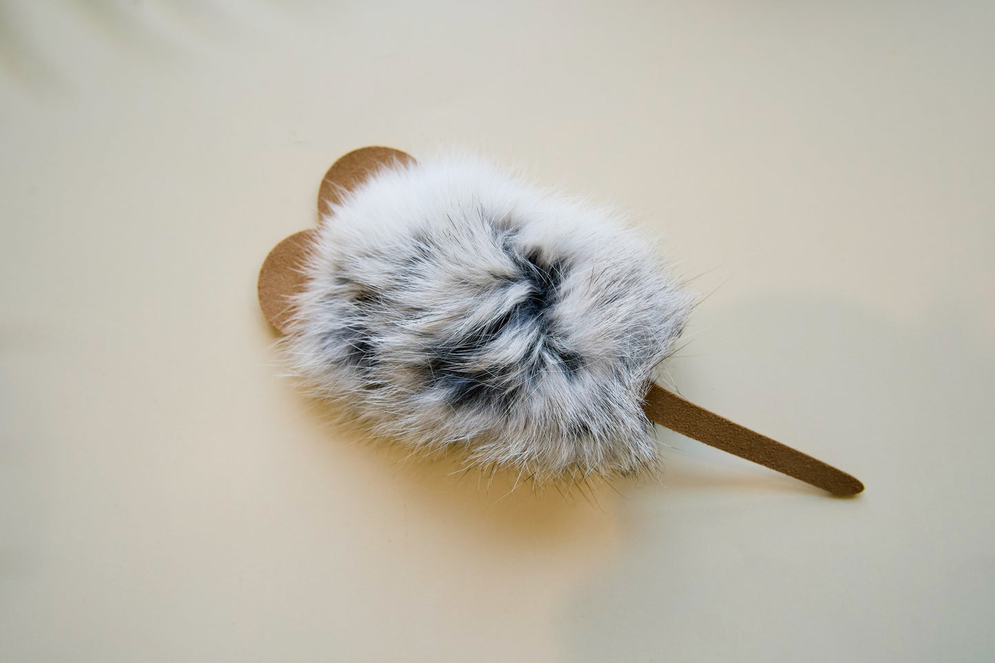 Mouse-shaped with leather ears and tails on a light background.