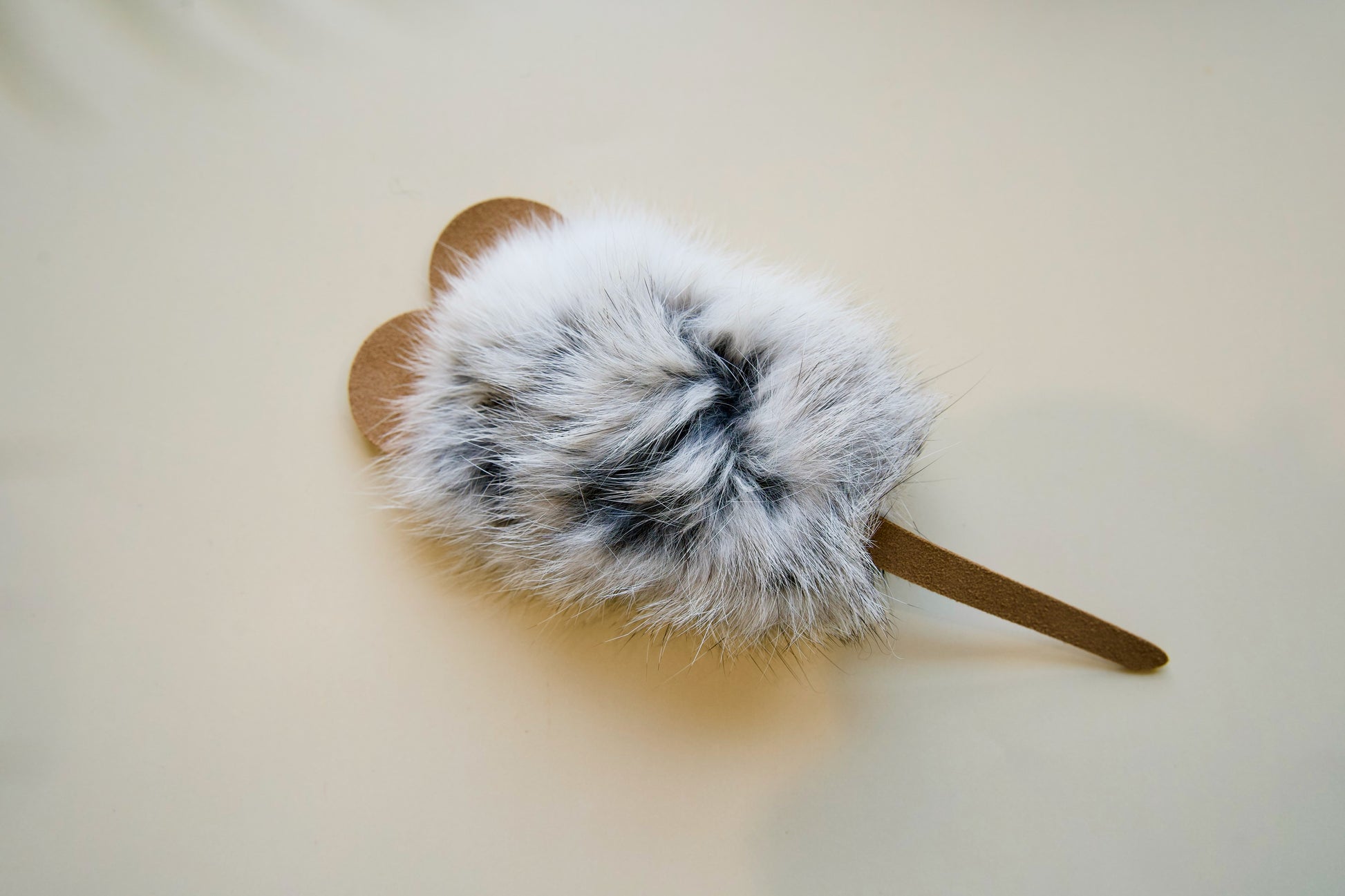 Mouse-shaped with leather ears and tails on a light background.