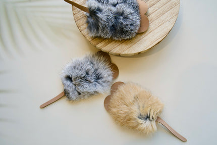 Trois jouets pour chats moelleux en forme de souris, sur un support en bois.