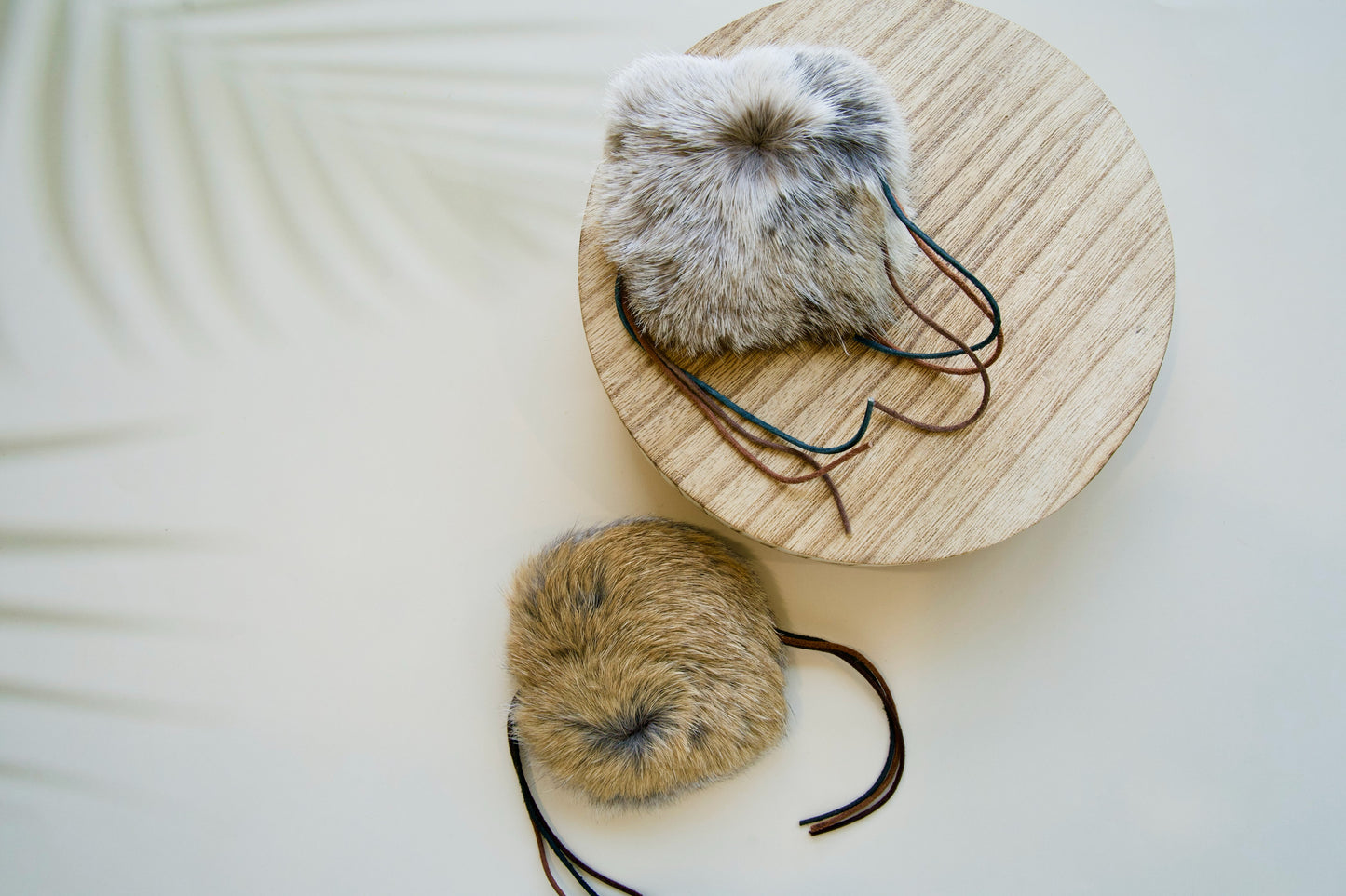 Two fur-lined cat toys on a wooden stand with a neutral background.