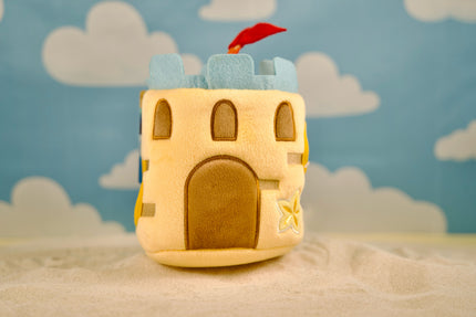 Jouet interactif château de sable pour chien avec pelle, râteau et étoile de mer en peluche cachés à l’intérieur.