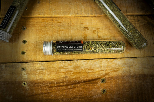 Catnip & Silver Vine product in a glass tube on a wooden surface.|Produit à base d'herbe à chat et de vigne argentée dans un tube en verre posé sur une surface en bois.