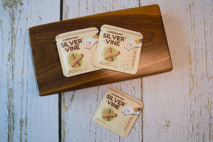 Trois petits sachets de jouets pour chats en Silvervine posés sur une planche en bois sombre.