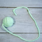 Small pastel green wool ball with tail for cats.