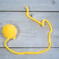 Small yellow wool ball with tail for cats.