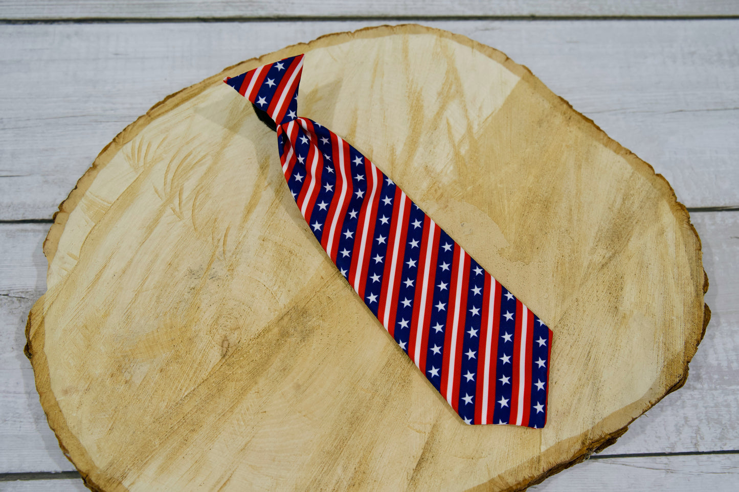 Cravate pour animal à motifs de drapeau américain, posée sur une surface en bois.