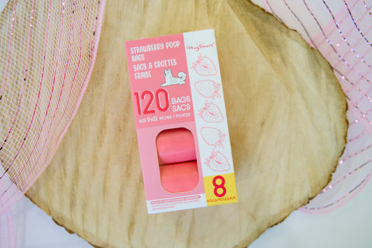 Strawberry Poop bags packaging on a wooden surface.|Sacs à crottes pour chiens à l'arôme de fraise, posés sur une surface en bois.