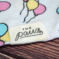 Close-up of The Paws logo on dog birthday bandana.