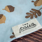 Gros plan sur le logo The Paws sur le bandana pour chien bleu clair.