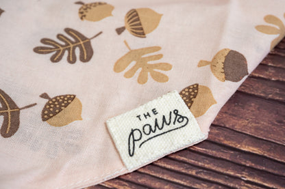 Close-up of The Paws logo on the soft pink cat bandana.
