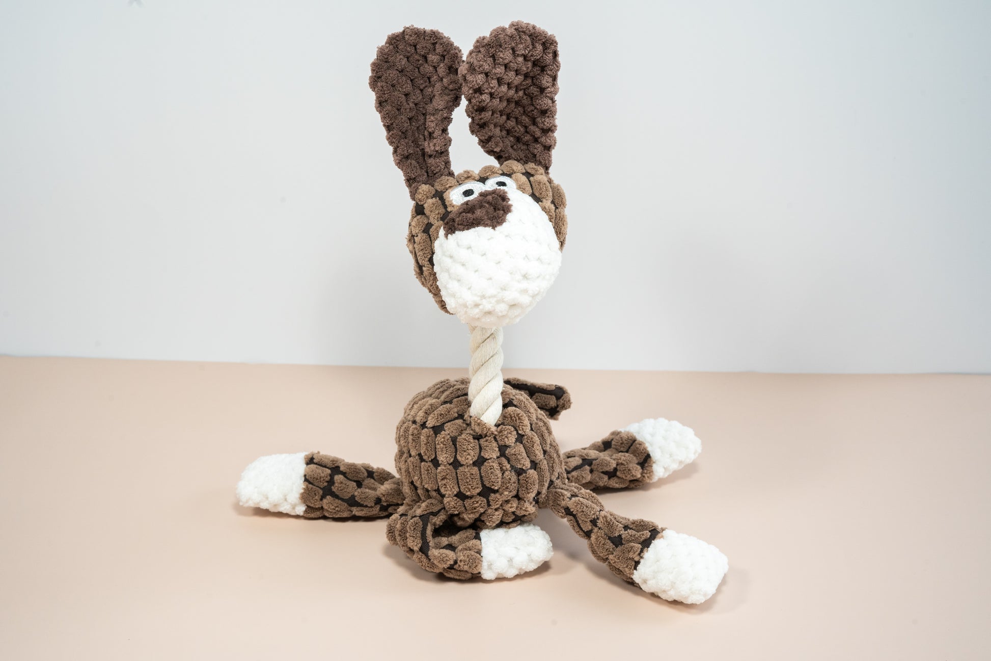 Plush dog toy in brown dog shaped with rope neck. | Chien marron en peluche pour chien avec cou en corde de cotton.