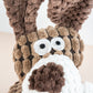 Close-up view of dog plush face with rope neck.