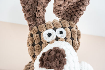 Vue rapprochée du visage en peluche de chien avec cou en corde.