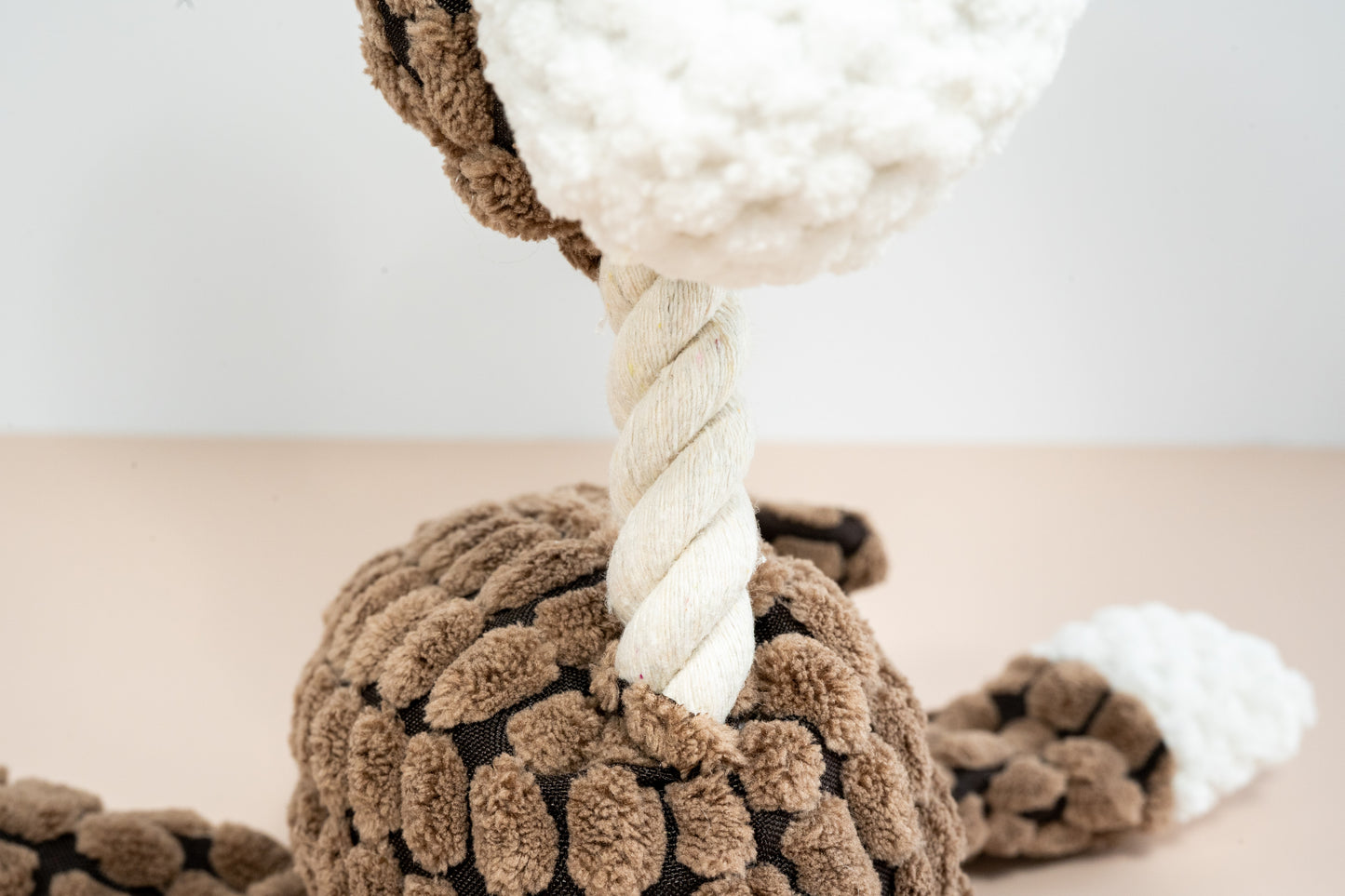 Close-up view of the rope neck of the dog plush.