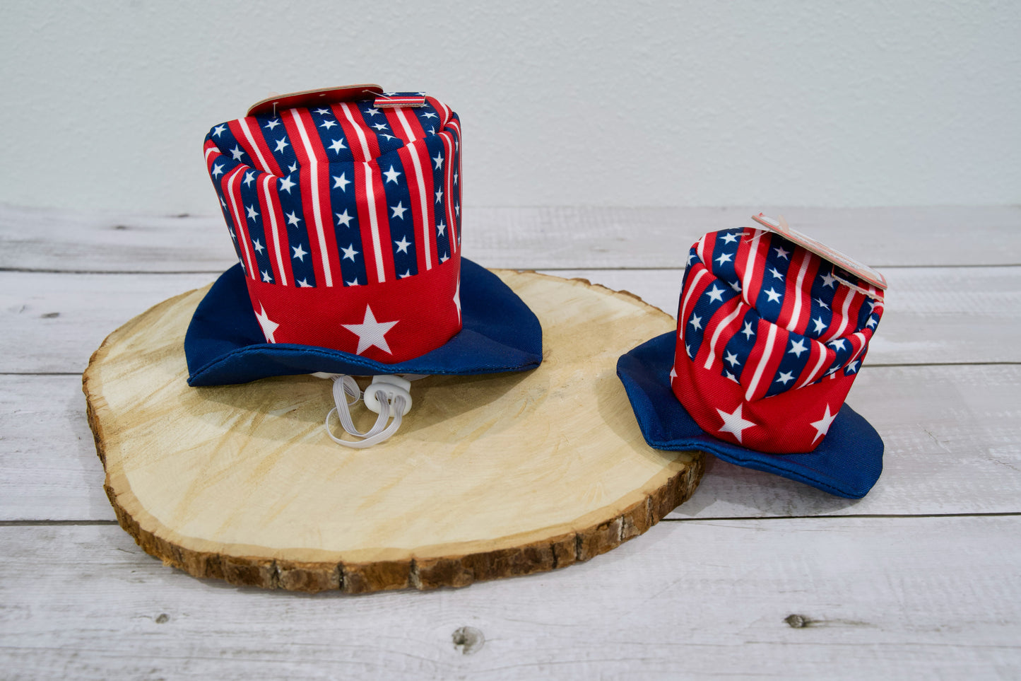 Deux chapeaux pour chien à motif de drapeau américain sur une surface en bois.