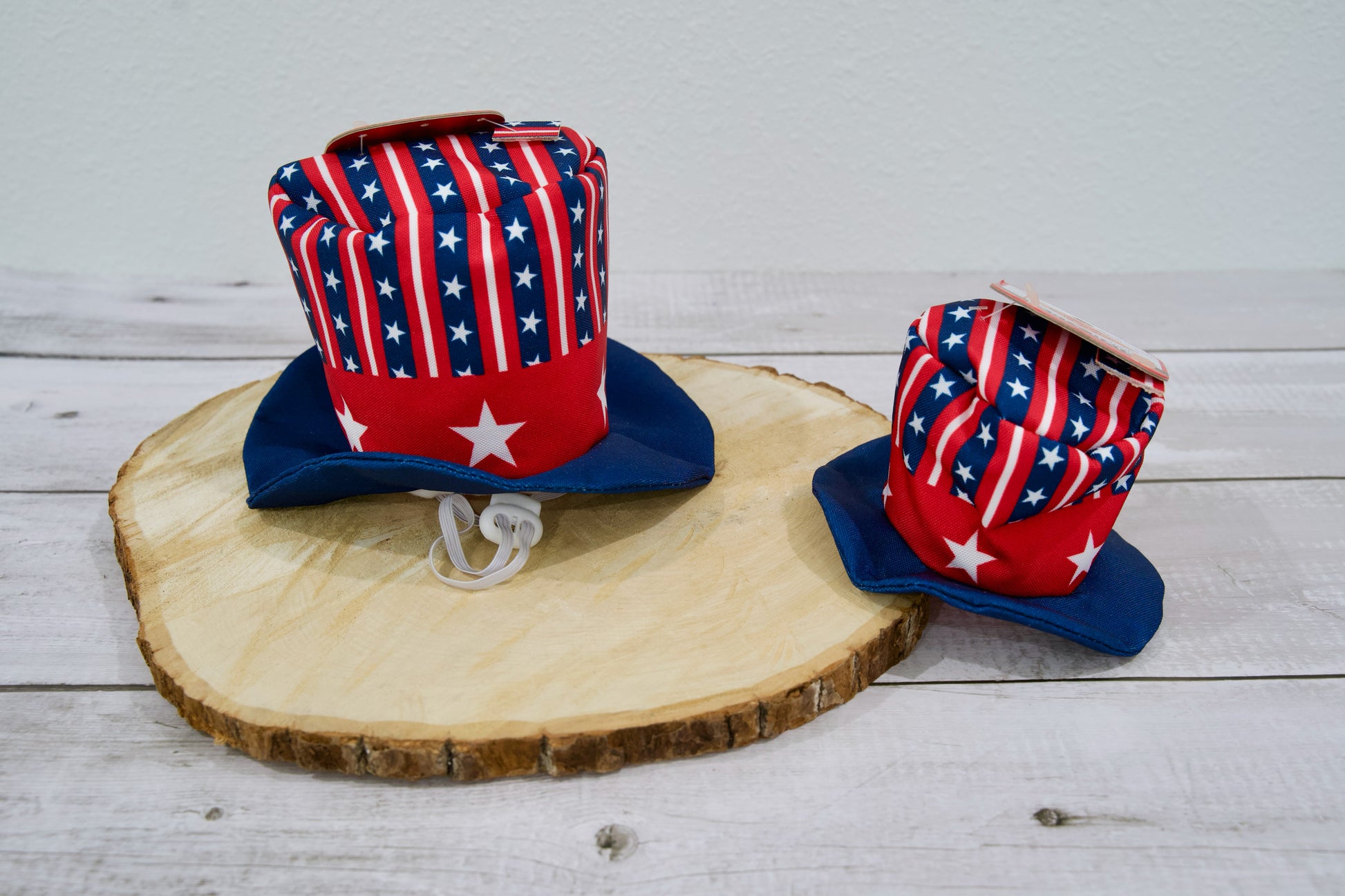 Deux chapeaux pour chien à motif de drapeau américain sur une surface en bois.