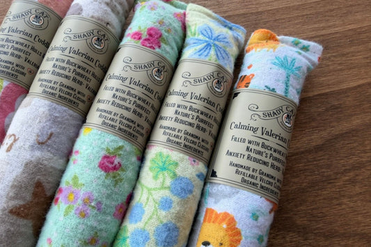 Cuddlers for cats of Shady Cat. Calming Valerian Catnip on a wooden surface.|Coussins à câliner pour chats de Shady Cat. Valériane et herbe à chat apaisantes, posées sur une surface en bois.