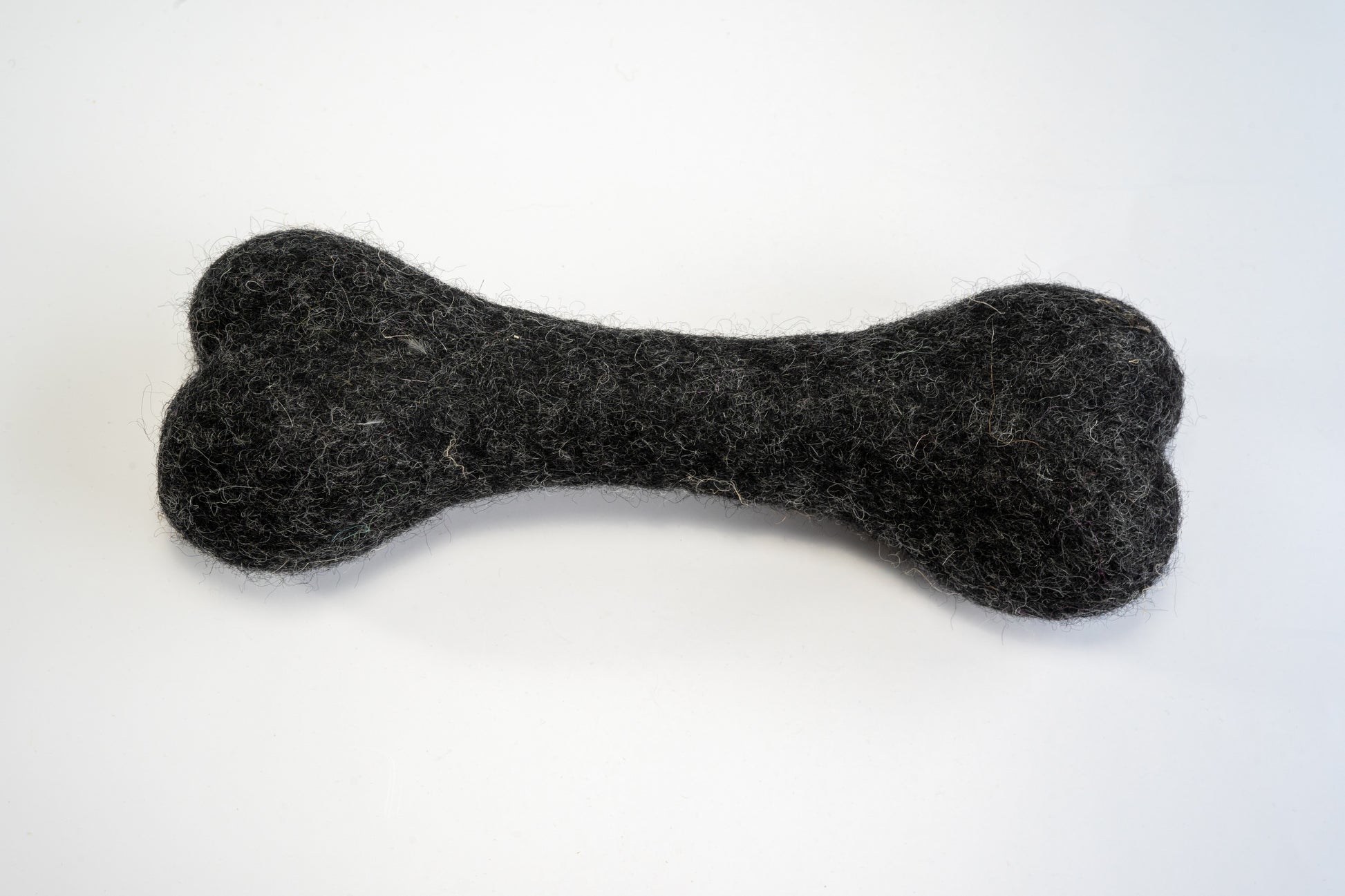 Large black wool dog chew bone. | Os de grande taille à mâcher pour chien en laine noir.