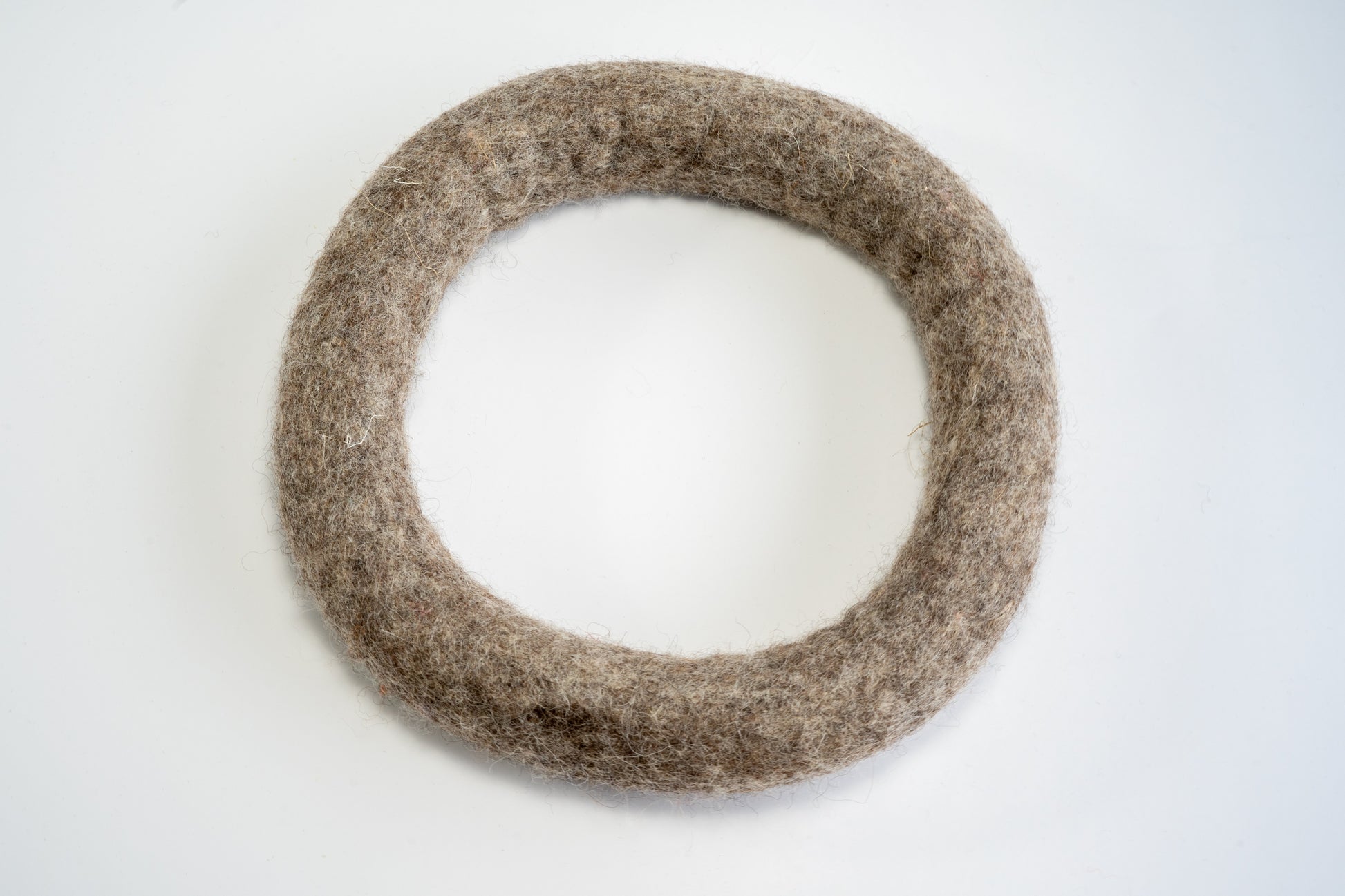 Medium dark brown wool frisbee ring for dogs. | Anneau en laine brune foncée de grandeur moyenne de type frisbee pour chiens.