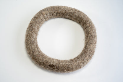 Anneau en laine brune foncée de grandeur moyenne de type frisbee pour chiens.