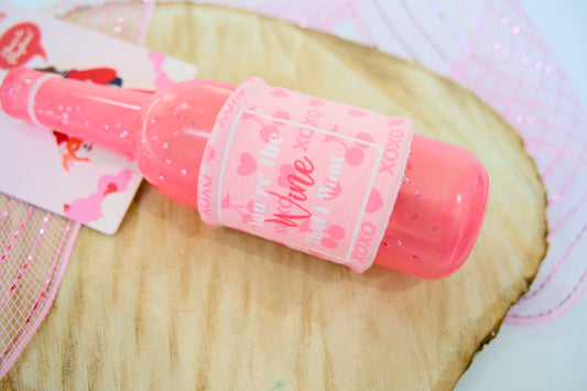 Pink bottle for dogs on a wooden surface.|Bouteille rose pour chiens, posé sur une surface en bois.