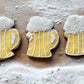 Three dog cookies shaped like beer mugs.