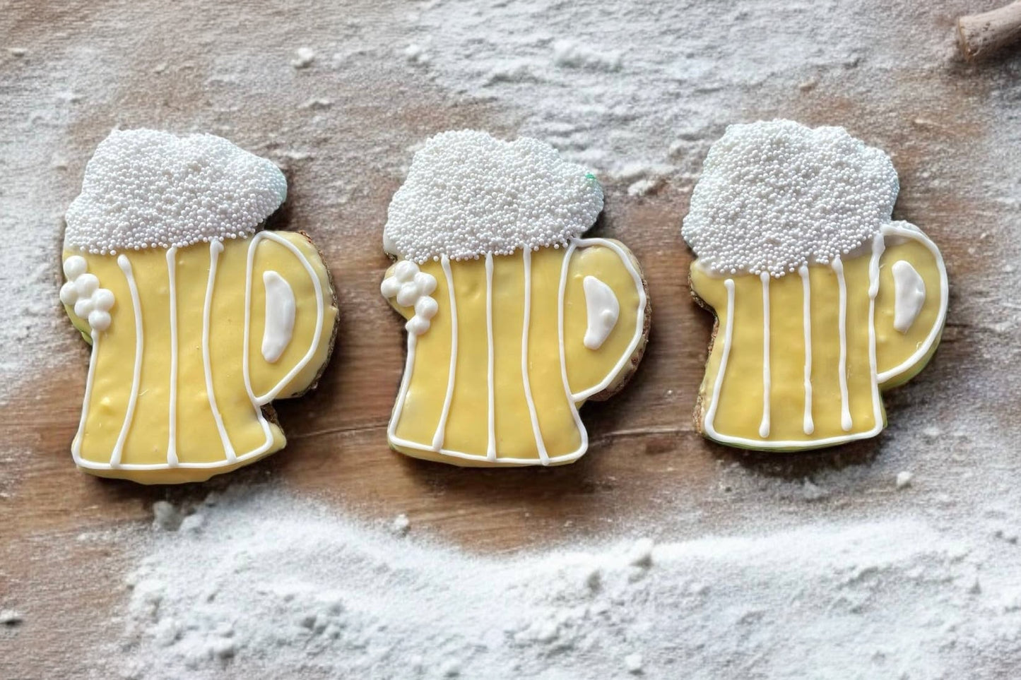 Three dog cookies shaped like beer mugs.