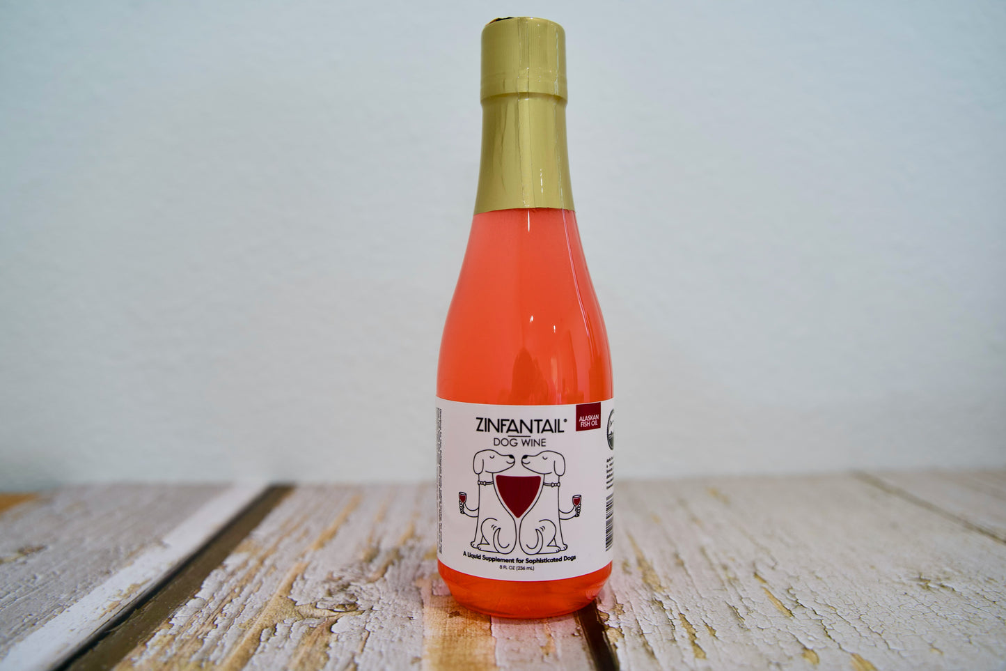 Bouteille de vin pour chiens Zinfantail sur une surface en bois, sur fond blanc.